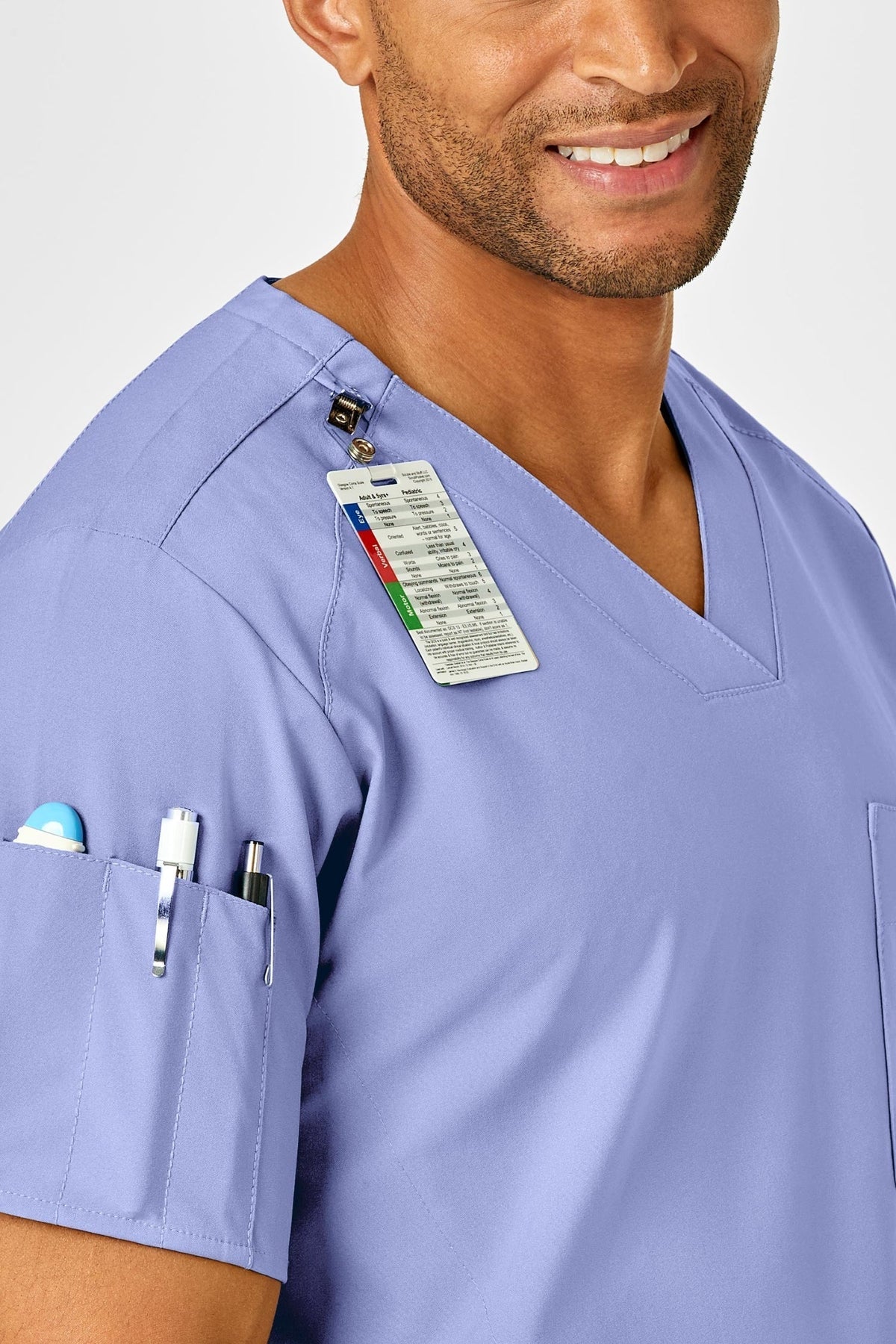 Zorgprofessional in een complete hemelsblauwe medische set met badge en pennen